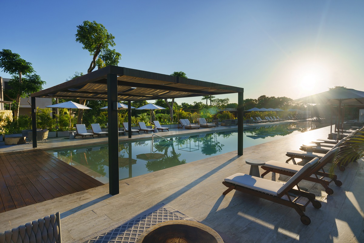Sunlit poolside with loungers and pergola at Hacienda Xcanatun, Angsana Heritage Collection.
